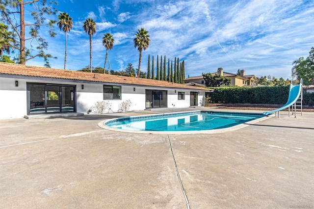 view of pool featuring a water slide and a patio area