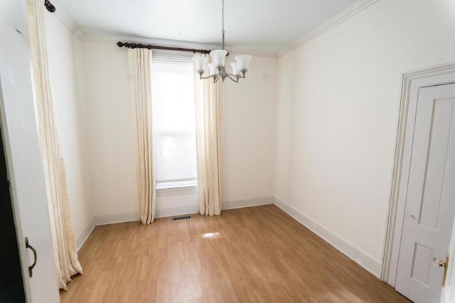 unfurnished room with a notable chandelier, light hardwood / wood-style floors, and ornamental molding