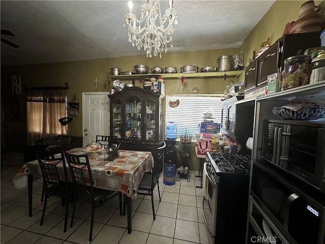 kitchen with a chandelier, gas range, a textured ceiling, and light tile patterned floors