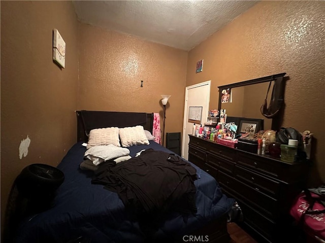 bedroom featuring a textured ceiling and vaulted ceiling