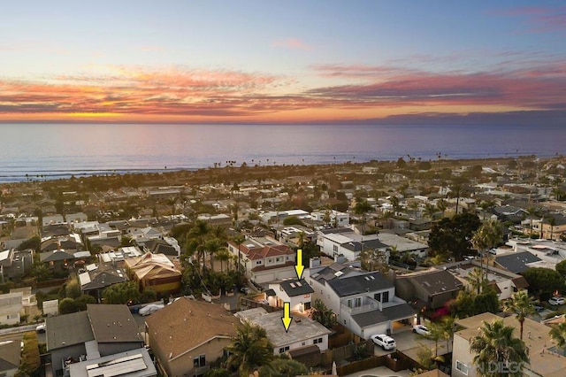 aerial view at dusk featuring a water view