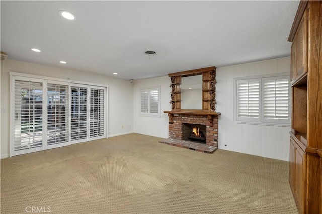 unfurnished living room with carpet floors and a brick fireplace