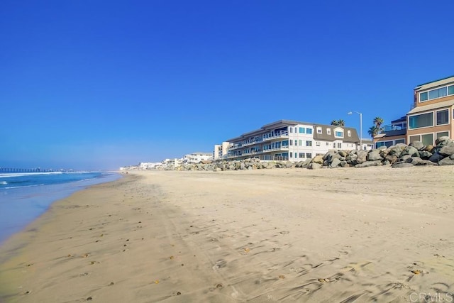 view of home's community featuring a beach view and a water view