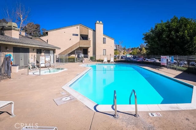 view of swimming pool with a patio area and a hot tub