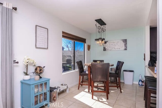 tiled dining area featuring a notable chandelier