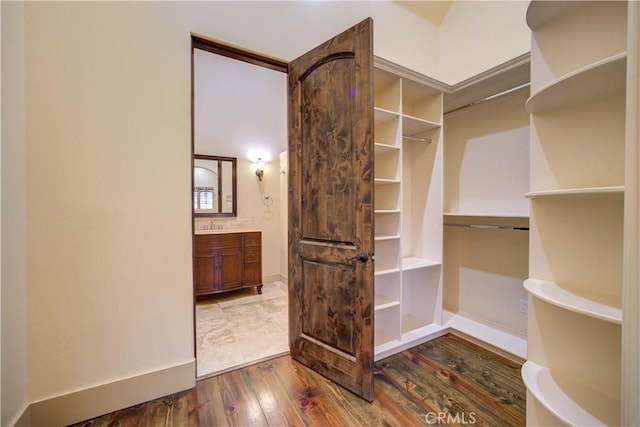 walk in closet with wood-type flooring and sink