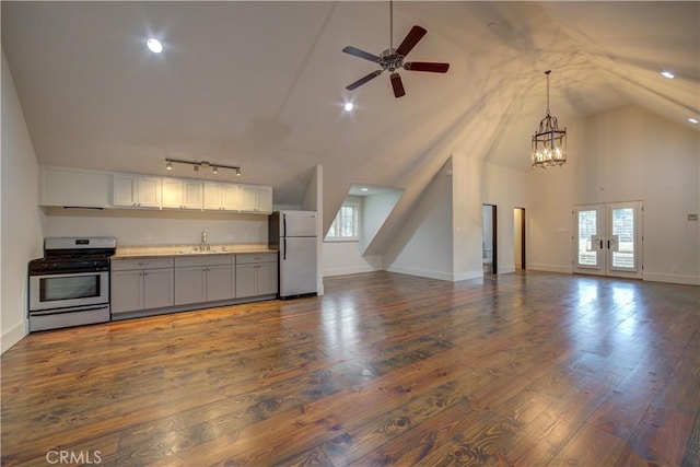 kitchen with dark wood-type flooring, french doors, white refrigerator, sink, and gas stove