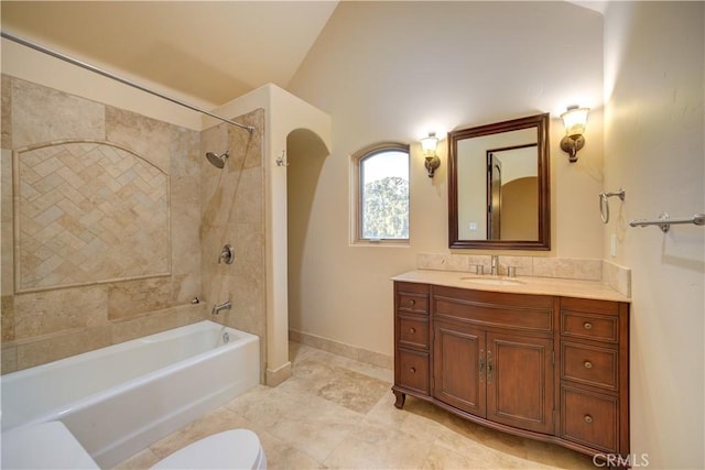 full bathroom with tiled shower / bath combo, toilet, vanity, and vaulted ceiling