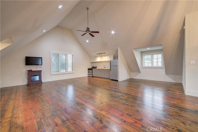 unfurnished living room featuring dark hardwood / wood-style flooring, ceiling fan, lofted ceiling, and sink