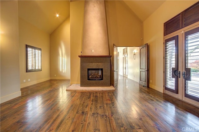 unfurnished living room featuring french doors, high vaulted ceiling, and dark wood-type flooring