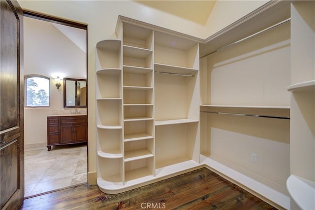 walk in closet with hardwood / wood-style floors and lofted ceiling