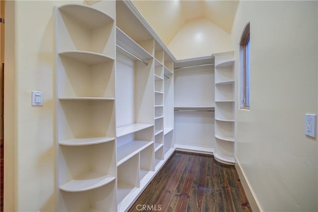 walk in closet with lofted ceiling and dark hardwood / wood-style floors