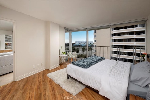 bedroom featuring floor to ceiling windows and wood-type flooring