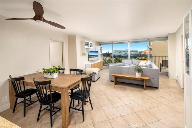 tiled dining area with a wall of windows and ceiling fan