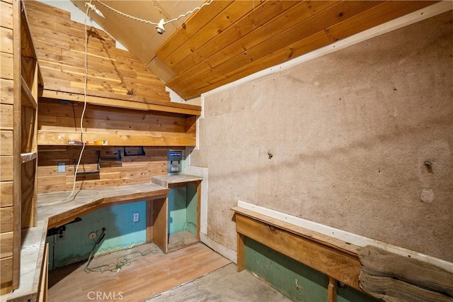 interior space featuring a workshop area, wooden ceiling, concrete floors, and lofted ceiling