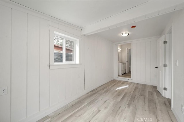 empty room with wood walls and light wood-type flooring