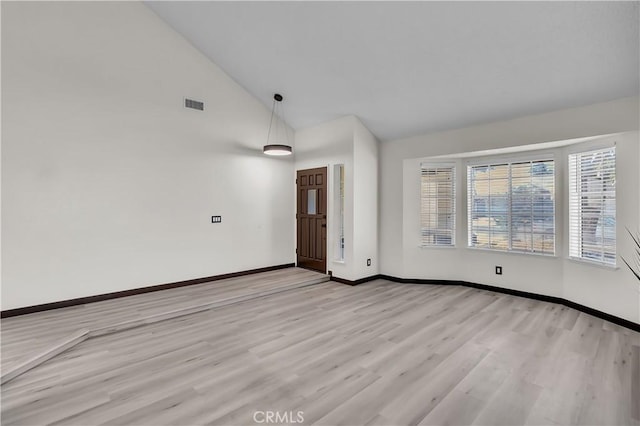 unfurnished room featuring light hardwood / wood-style flooring and high vaulted ceiling