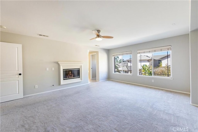 unfurnished living room featuring light colored carpet and ceiling fan