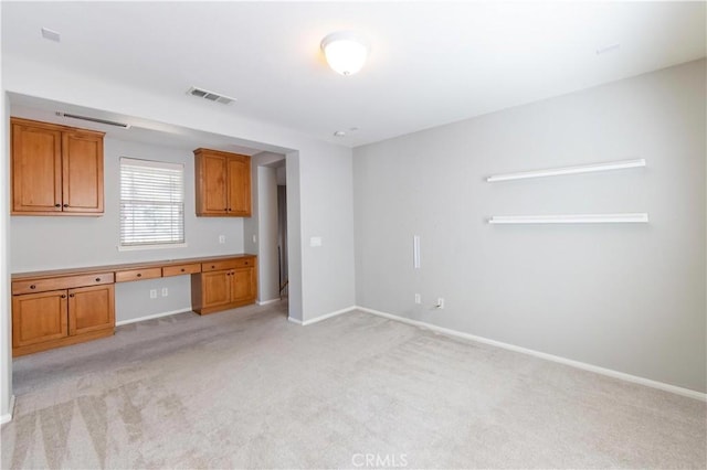 kitchen with light carpet and built in desk