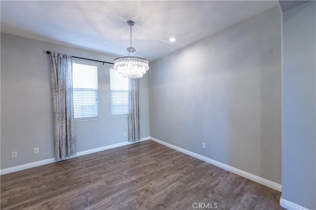 unfurnished room with hardwood / wood-style floors and a chandelier