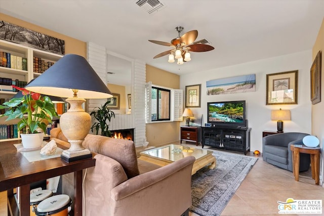 living room featuring ceiling fan, light tile patterned floors, and a fireplace