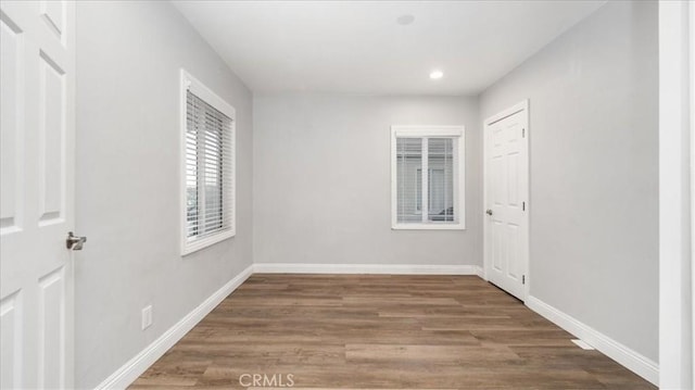 unfurnished room with recessed lighting, wood finished floors, and baseboards