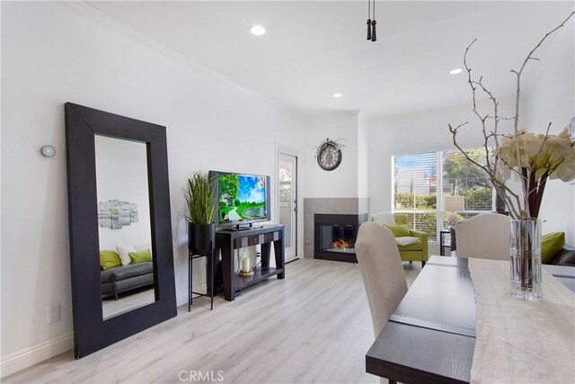 office featuring crown molding, a fireplace, and light hardwood / wood-style floors