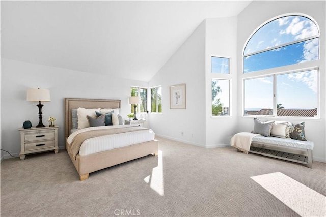 bedroom featuring light colored carpet and high vaulted ceiling