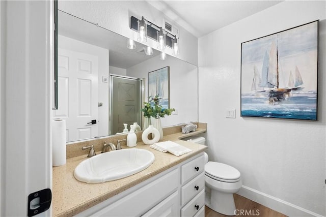 bathroom with vanity, toilet, wood-type flooring, and a shower with shower door