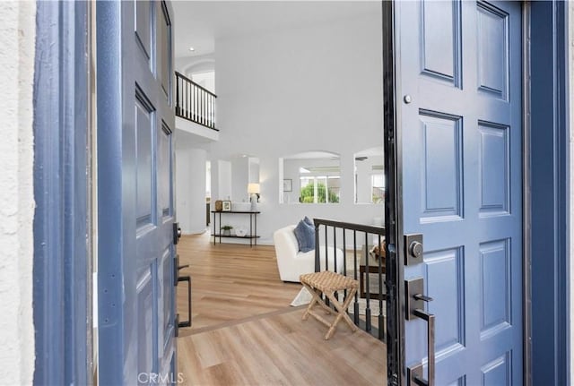 foyer entrance featuring hardwood / wood-style flooring and a towering ceiling