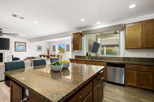 kitchen featuring dark hardwood / wood-style flooring, dishwasher, a center island, and sink