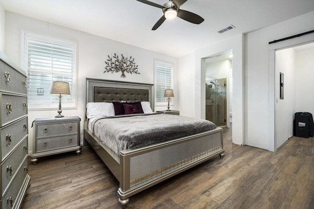 bedroom featuring connected bathroom, dark hardwood / wood-style floors, multiple windows, and ceiling fan