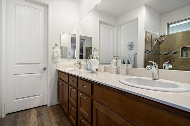 bathroom featuring tiled shower, vanity, and hardwood / wood-style flooring