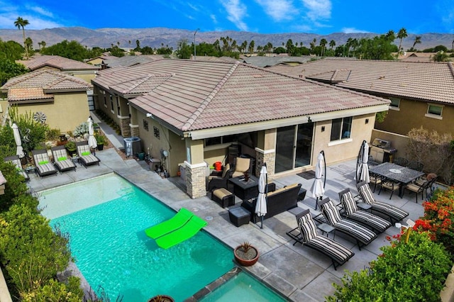 back of property with an outdoor living space, a patio area, a mountain view, and central air condition unit