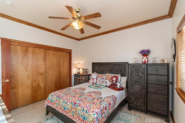 bedroom with ceiling fan, light hardwood / wood-style floors, crown molding, and a closet