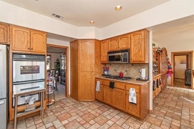 19985 Red Feather Rd, Apple Valley, CA 92307 - kitchen with stainless steel appliances, brick patterned flooring, backsplash, light countertops, and recessed lighting