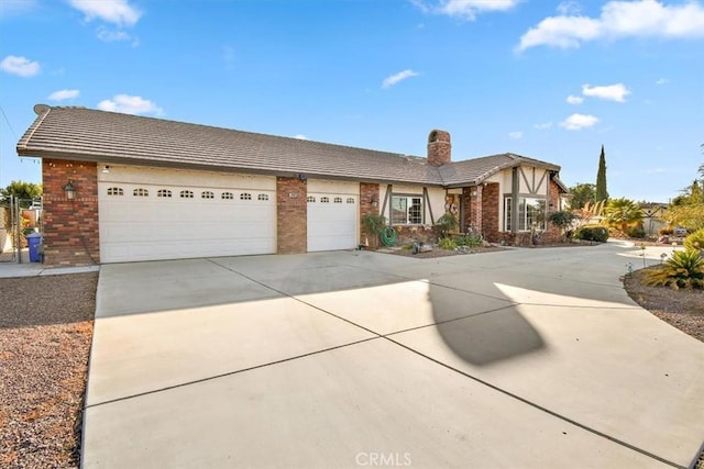 19985 Red Feather Rd, Apple Valley, CA 92307 - view of front of property with a chimney, concrete driveway, brick siding, an attached garage, and a tiled roof