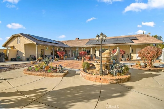 19985 Red Feather Rd, Apple Valley, CA 92307 - back of property featuring roof mounted solar panels, stucco siding, and covered porch
