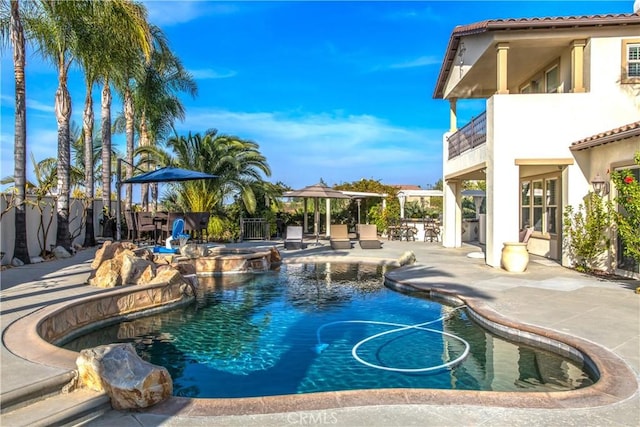 view of swimming pool featuring an in ground hot tub and a patio