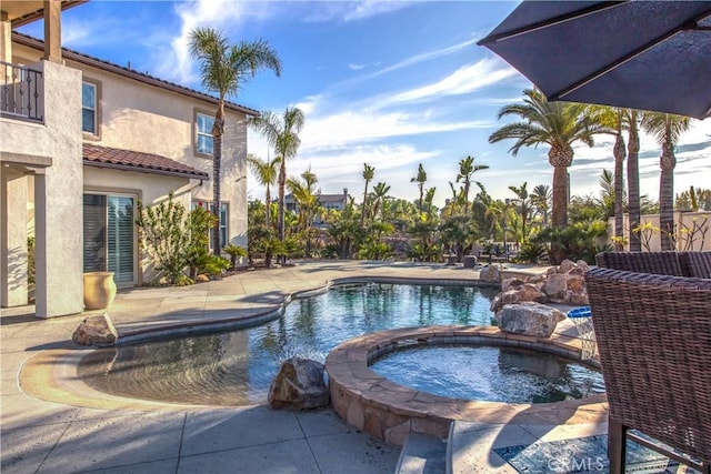 view of swimming pool featuring an in ground hot tub