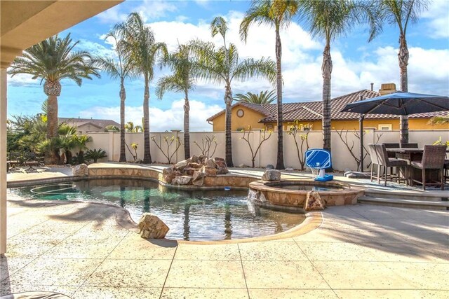 view of swimming pool featuring a patio area and an in ground hot tub