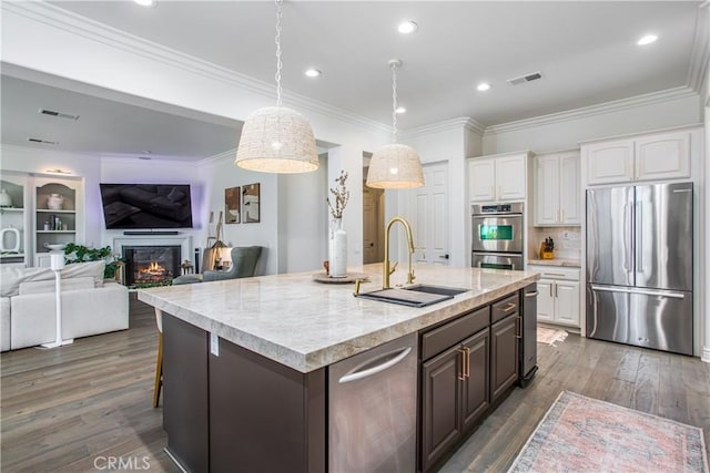 kitchen with appliances with stainless steel finishes, dark brown cabinetry, dark wood-type flooring, sink, and white cabinetry