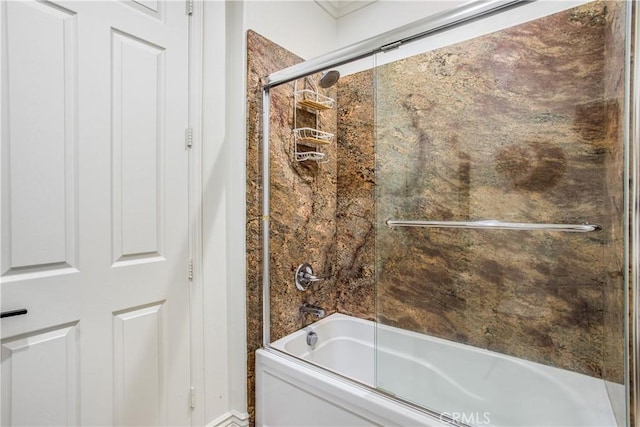 bathroom with bath / shower combo with glass door