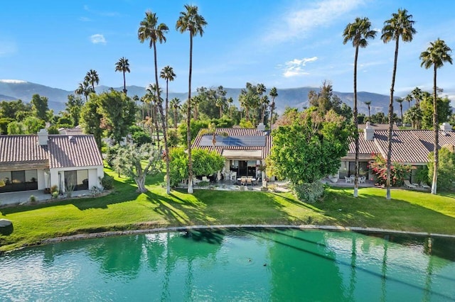 view of pool with a yard and a water and mountain view