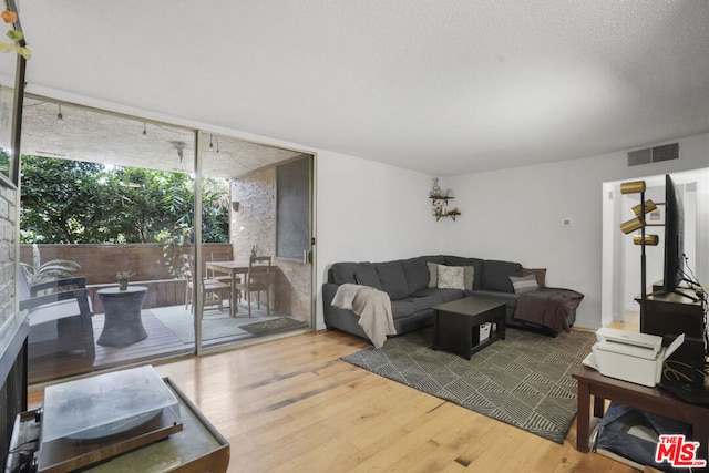 living room with hardwood / wood-style flooring and a textured ceiling