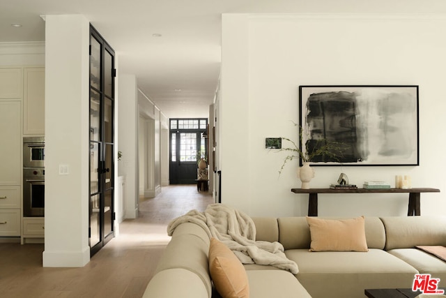 interior space featuring light wood-type flooring and crown molding