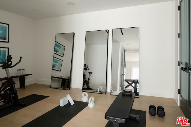 exercise area with light hardwood / wood-style flooring