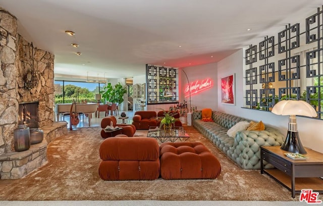 living room featuring carpet flooring and a stone fireplace