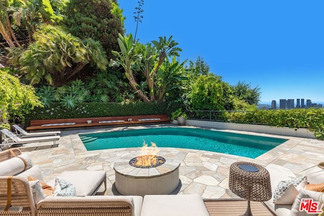 view of swimming pool with a patio and an outdoor fire pit