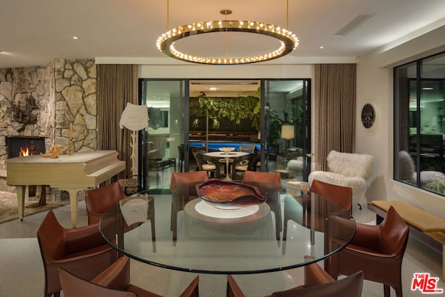 dining space featuring a fireplace and an inviting chandelier